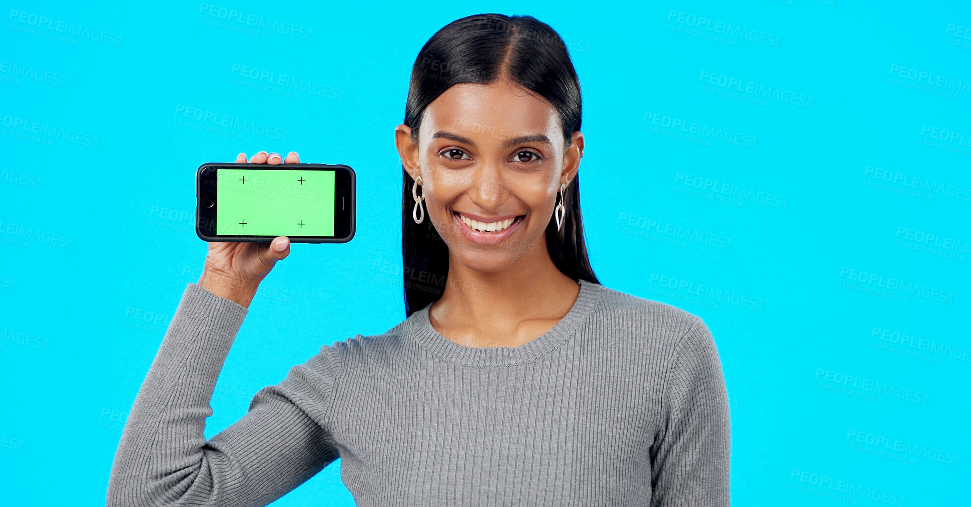 Buy stock photo Portrait, woman or advertising green screen of smartphone, newsletter or promotion coming soon in studio on blue background. Happy indian model, mobile tracking markers or launch information about us