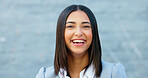 Cheerful woman laughing and giggling about something funny while standing outside against a grey wall with copy space. Happy businesswoman having fun and expressing positivity and a playful attitude