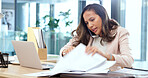 Female advertising agent looking busy while talking on a phone call and searching through documents on a messy table in an office. Female marketing professional trying to find an important form