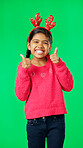 Child portrait, christmas and thumbs up on green screen for motivation or mindset. Smile of girl kid on studio background with antlers headband excited for holiday celebration thank you or like emoji