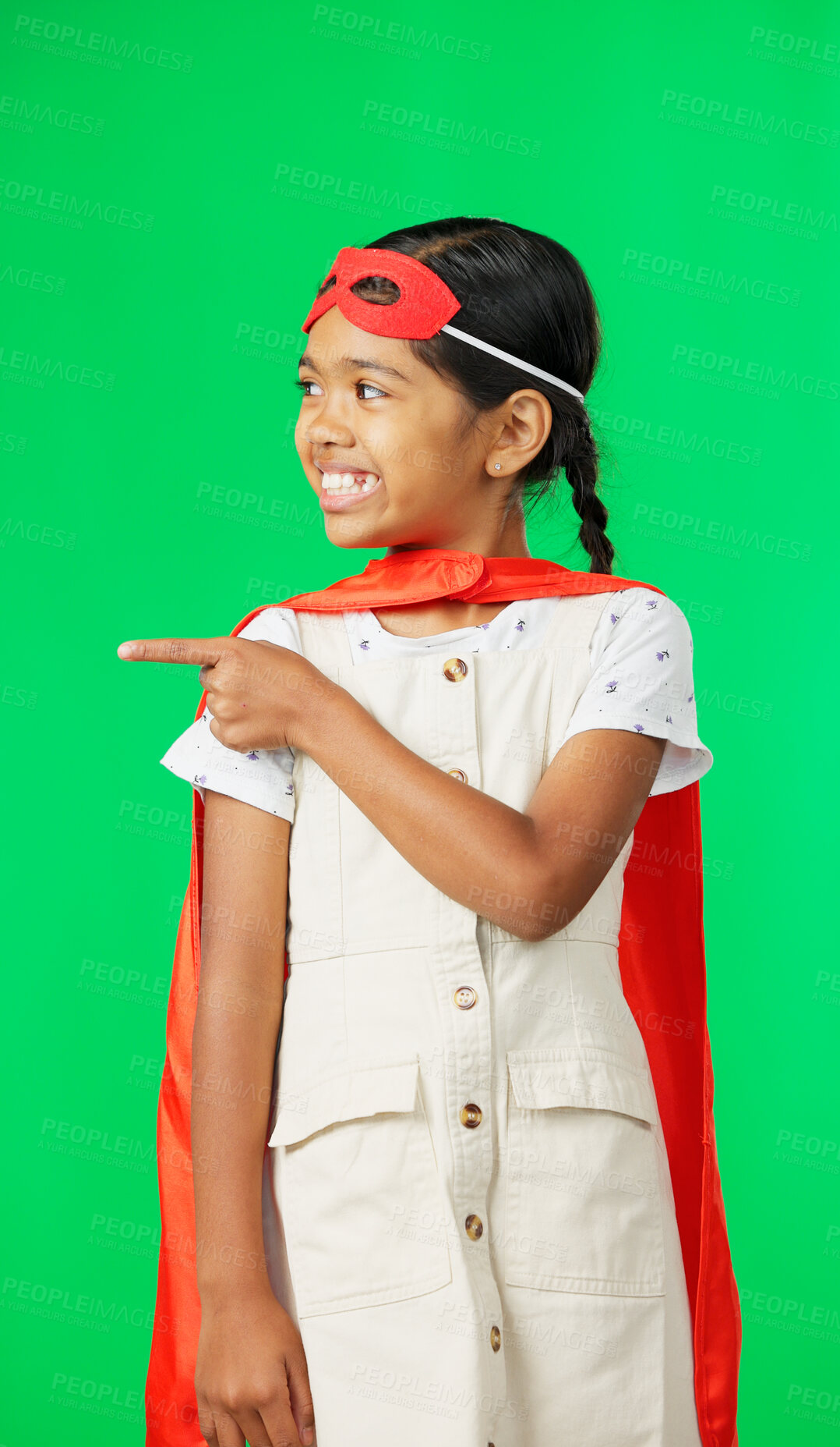 Buy stock photo Superhero, pointing and advertising of child on green screen for fantasy, cosplay costume and comic character. Girl, justice and mask of kid in studio for freedom with a smile and happy with fun