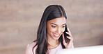 Secretary talking on a phone while working on a computer at a front desk. Cheerful young receptionist with a friendly tone scheduling appointments and confirming meetings with clients in an office