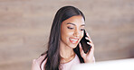 Secretary talking on a phone while working on a computer at a front desk. Cheerful young receptionist with a friendly tone scheduling appointments and confirming meetings with clients in an office