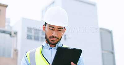 Construction worker holding a digital tablet while doing inspection. Organized male engineer or technician in a hardhat checking project plan with latest tech. Worker looking or overseeing operations