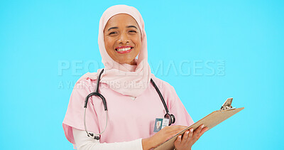 Buy stock photo Muslim woman, doctor and clipboard in studio portrait, smile or pride for medical career by blue background. Islamic person, nurse and checklist for insurance info, notes or administration for health
