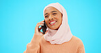 Phone call, talking and communication with muslim woman in studio for networking, contact and conversation. Connection, technology and chatting with female on blue background for discussion and news