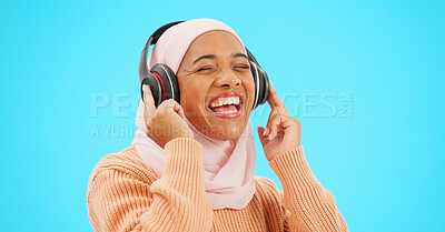 Buy stock photo Islamic girl, headphones and music in studio, smile and excited for audio streaming by blue background. Muslim person, listening and happy for radio, comedy podcast and comic laugh with sound tech