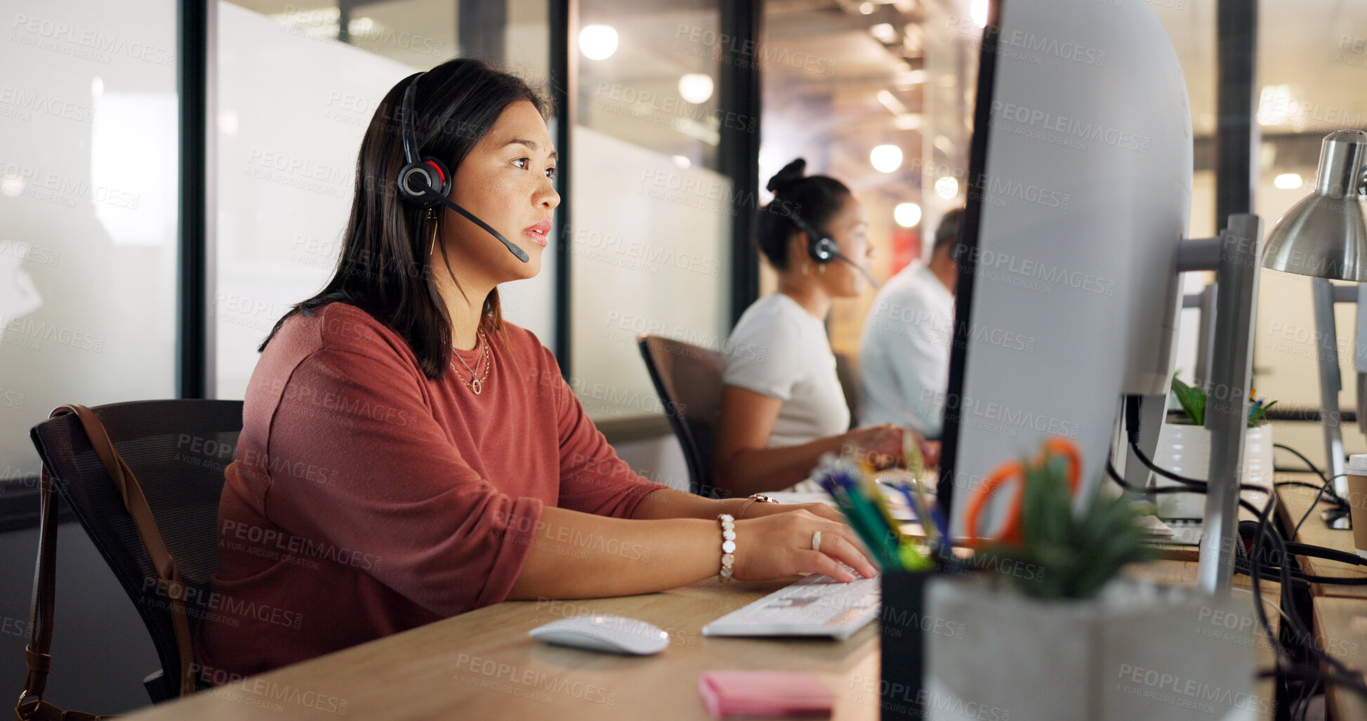 Buy stock photo Asian woman, call center and night in customer support, telemarketing or service with headphones at office. Female person, consultant or agent working late in online advice, contact us or help