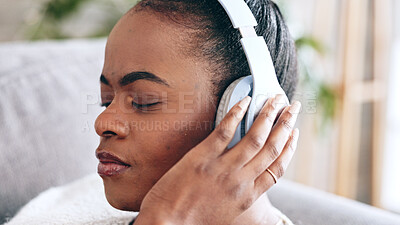 Relax, music and black woman on the sofa with headphones for radio, podcast or audio. Peace, stress relief and African lady listening to a calm track, recording or enjoying songs on the couch