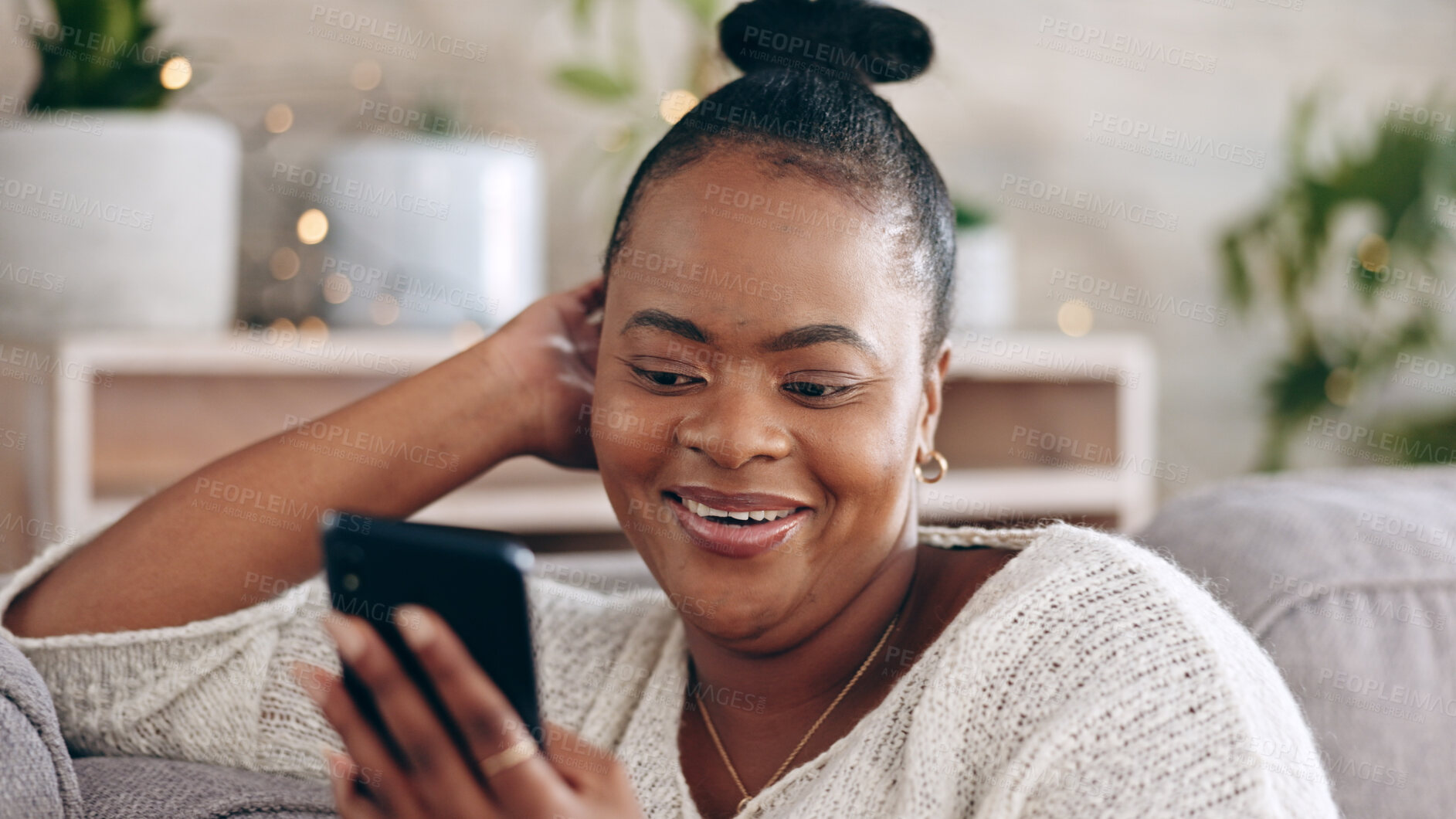 Buy stock photo Black woman, reading and using phone with smile in home with social media, mobile app and communication online.  Funny, meme or person on couch streaming video or comedy on cellphone in living room