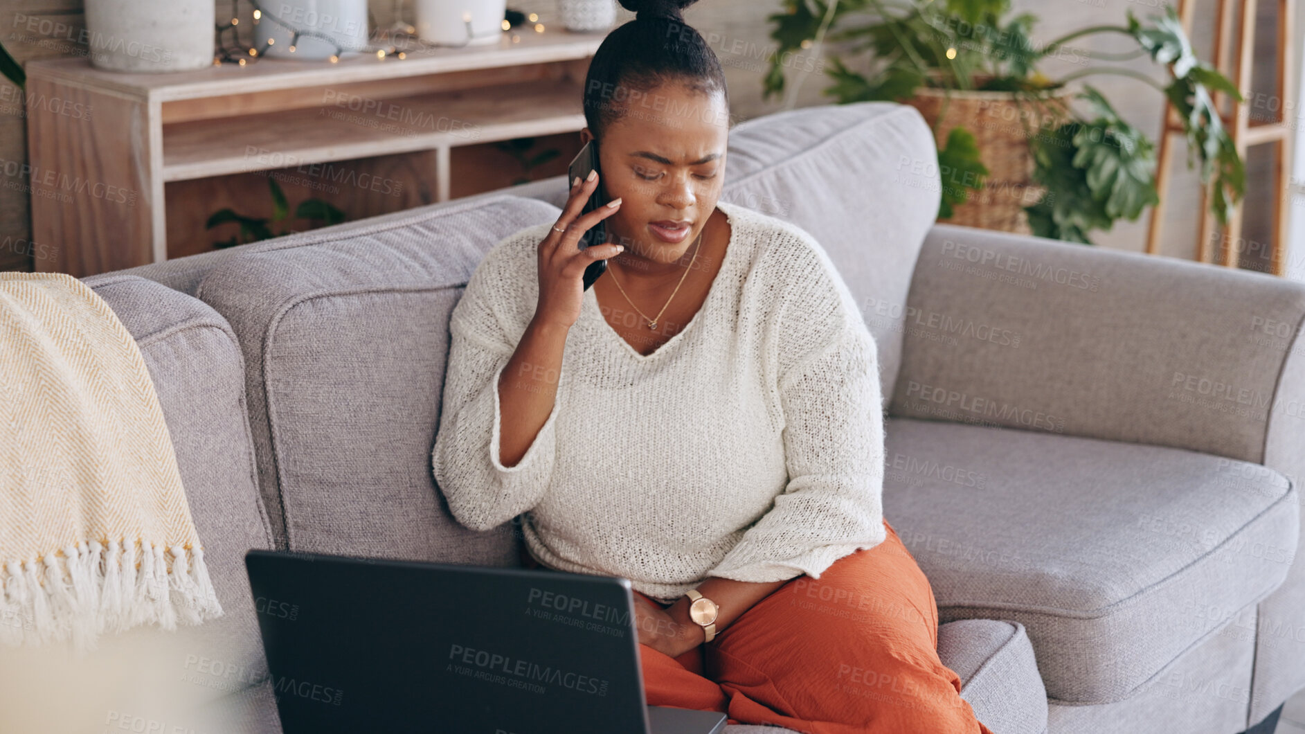 Buy stock photo Laptop, phone call and worry with a black woman on a sofa in the living room of her home for problem solving. Computer, communication and a concerned person talking on her mobile for networking