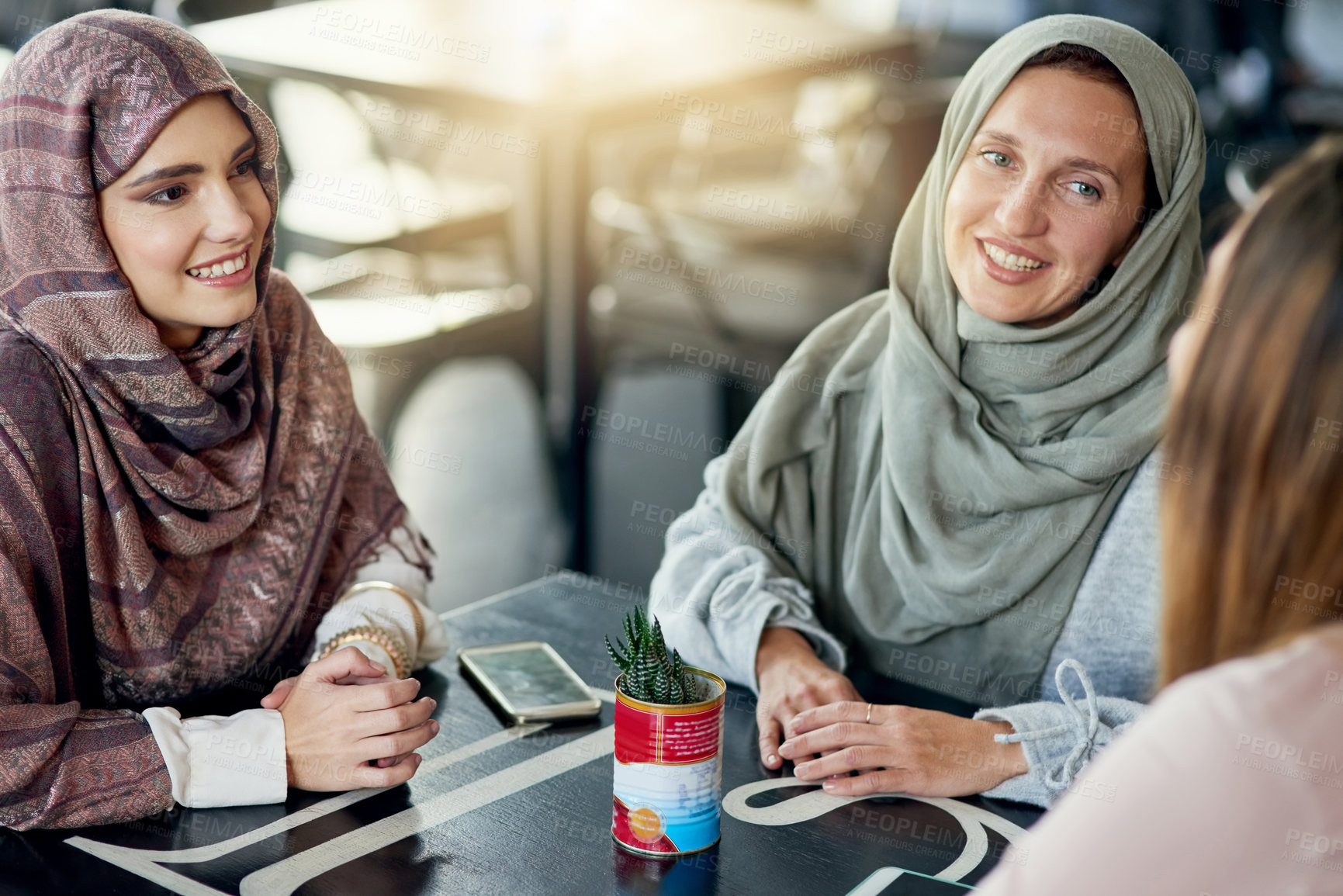Buy stock photo Friends, relax and Muslim women in coffee shop, bonding and talking together. Cafe, happy and Islamic girls, group or people chatting, conversation and discussion for social meeting in restaurant.