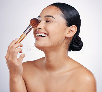 Buy stock photo Face, makeup brush and beauty of a woman in studio for skin glow, dermatology and cosmetics. Happy female model laugh with cosmetic tools in hand for self care and facial shine on a white background