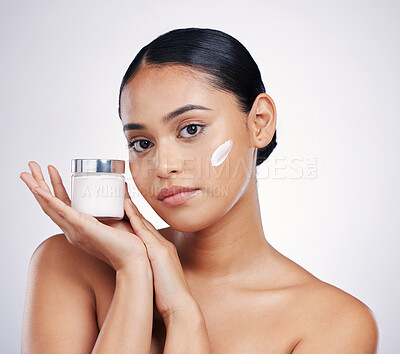 Buy stock photo Face, beauty and skin cream for woman in studio for glow, dermatology and cosmetics. Portrait of female model with product container in hand for skincare, self care and wellness on a white background