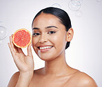Face, grapefruit and beauty portrait of woman in studio for skin glow, dermatology or natural cosmetics. Model person with fruit and bubbles for detox, healthy diet and skincare on a white background