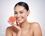 Face, grapefruit and beauty portrait of a woman in studio for skin glow, dermatology or natural cosmetic. Happy person with fruit and bubbles for detox, healthy diet or skincare on a white background