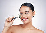 Face roller, skin care and a woman in studio for beauty glow, dermatology or natural cosmetic. Portrait of happy female model with tools for facial massage and skincare benefits on a white background