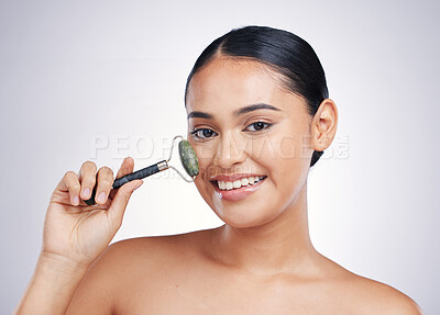 Buy stock photo Face roller, skin care and a woman in studio for beauty glow, dermatology or natural cosmetic. Portrait of happy female model with tools for facial massage and skincare benefits on a white background