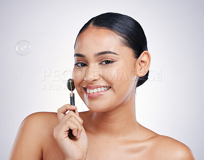 Buy stock photo Smile, face roller and portrait a woman in studio for beauty glow, dermatology or natural cosmetics. Happy aesthetic model with tools for a facial massage and skincare results on a white background