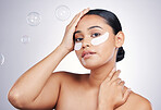 Eye mask, face and a woman in studio for beauty glow, dermatology or natural cosmetics. Portrait of aesthetic model person with a skincare patch and bubbles for facial self care on a white background