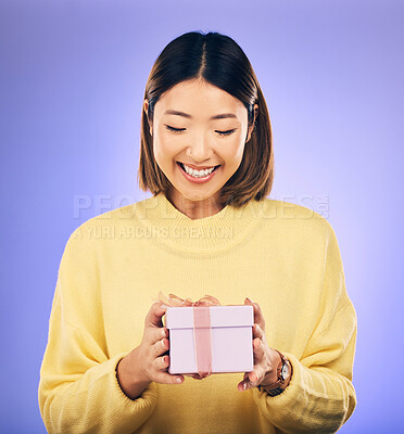 Buy stock photo Happy, smile and woman with a gift box in a studio for a birthday, achievement or celebration. Happiness, excited and Asian female model with a present package for party isolated by purple background