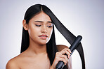 Hair, stress and woman with electric straighter for straight hairstyle, luxury salon treatment and white background in Brazil. Beauty, heat damage and face of latino model with flat iron in studio.