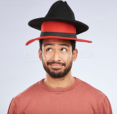 Buy stock photo Confused, hats and young man in a studio with a thinking, idea or contemplating face expression. Pensive, thoughtful and Indian male person with fun head accessories isolated by a white background.