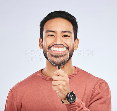 Buy stock photo Portrait, teeth and man with a magnifying glass, smile and search against a studio background. Face, male person and model with a tool, zoom and happiness with oral health, dental hygiene and care