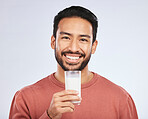Man with milk, drink and health with nutrition, calcium and vitamins with vanilla shake isolated on studio background. Dairy product in glass, beverage and male person smile, healthy and portrait