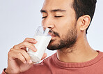Man drinking milk, health and nutrition with calcium, vitamins and nutrition isolated on studio background. Dairy product in glass, beverage and male person with healthy diet for strong bones