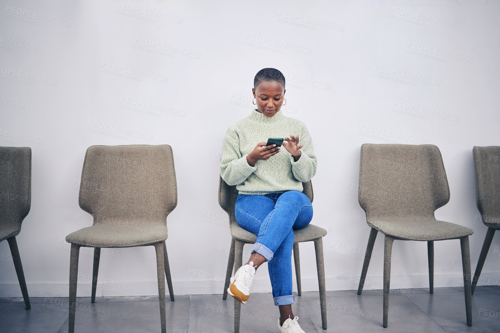 Buy stock photo Black woman, phone and sitting on a chair in a waiting room with internet connection for social media. African female person in line for recruitment interview with a smartphone for communication app