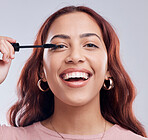 Portrait, beauty or happy woman with mascara makeup, cosmetics or product brush laughing in studio. Smile, face or girl model smiling with eyelashes tool for make up or self care on white background 