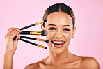 Happy woman, portrait smile and makeup brushes for beauty cosmetics against a pink studio background. Isolated female person or model smiling in satisfaction for cosmetic tools, grooming or facial