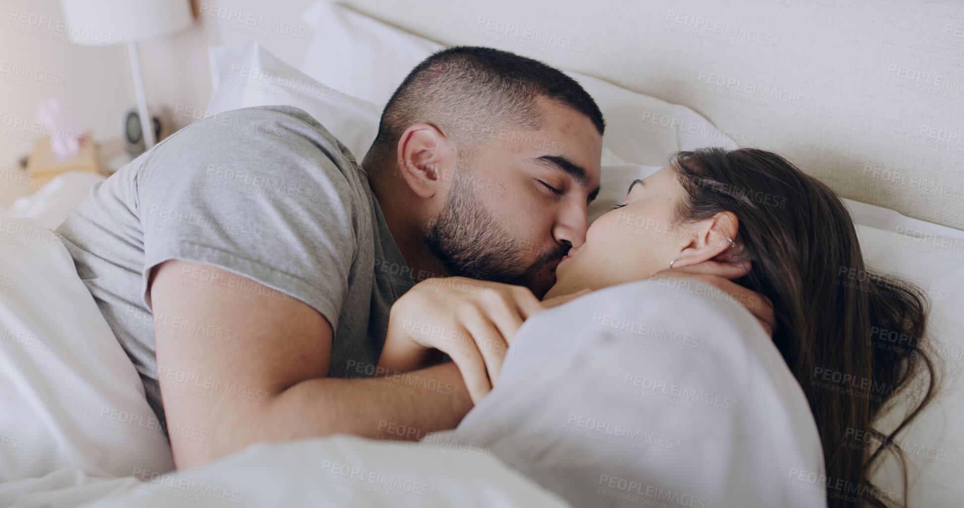 Buy stock photo Couple, kiss and bedroom for love, care and romance of intimacy, special moment and quality time together at home. Man, woman and kissing partner for relationship, honeymoon and relax in the morning