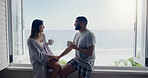 Couple, coffee and window on holiday by sea with conversation, romance and love in summer sunshine. Woman, man and drink with latte, espresso or match on vacation with ocean view in home with bonding