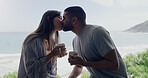 Couple, kiss and coffee in morning on balcony with love, romance and care on holiday by ocean with sunshine. Man, woman and kiss with drink, espresso or matcha on vacation by sea with bond in summer