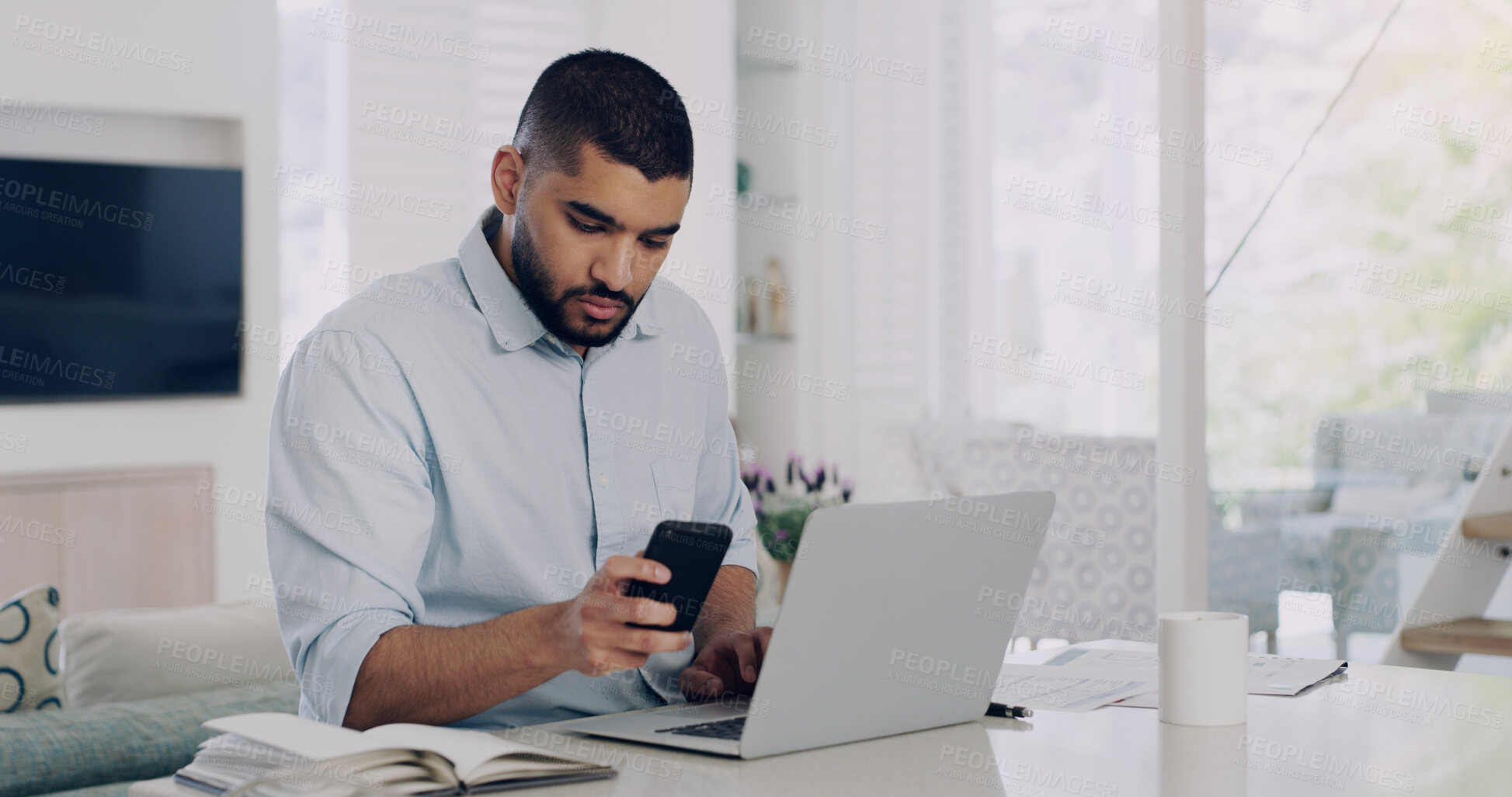 Buy stock photo Man, remote work and smartphone at laptop in home for reading notification, digital planning and online information. Male freelancer, cellphone and working on computer, internet and check mobile app