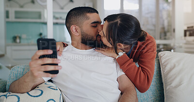 Buy stock photo Love, kiss and couple on sofa with phone, embrace and surfing social media post or or streaming online. Cellphone, man and woman on couch, kissing and hugging in romantic relationship in living room.