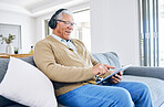 Old man laughing, relax with tablet and headphones at home, retirement and technology, streaming comedy online. Surfing internet, watching funny video and elderly male person sitting on couch