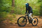 Motion blur, mountain bike and cycling in forest for adventure, speed and power. Athlete, extreme sports and bicycle for outdoor action, off road competition and cardio race for adrenaline in nature