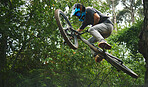 Extreme sports, jump and mountain bike with man in nature for cycling, action and adventure from below. Bicycle, athlete and stunt performance in air for skill, adrenaline and competition challenge 