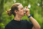 Man breathe asthma pump outdoor in garden, park and help with health risk, cough treatment and stress of exercise. Male runner breathing medicine inhaler in nature for lungs, oxygen or allergy relief