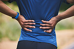 Back pain, fitness and hands of man in park after workout, exercise and training or running outdoors. Medical emergency, health and male person with muscle strain, spine injury and ache in nature