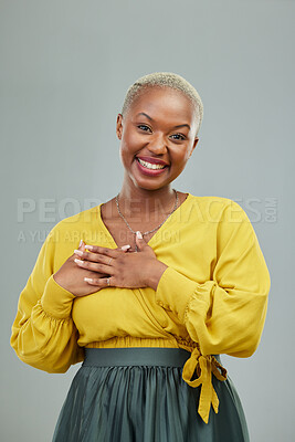 Buy stock photo Portrait, thank you and hands on chest of happy woman in studio with love sign on wall background. Face, smile and hand on heart by female person showing gratitude, kindness and self care or honesty