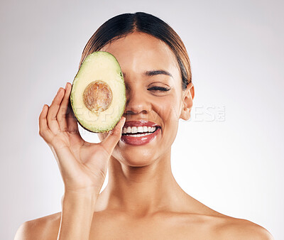 Buy stock photo Skincare, smile and woman with avocado in studio for organic, facial or treatment on grey background. Face, avo and girl model with fruit for eco, vegan or skin detox with anti aging or antioxidants