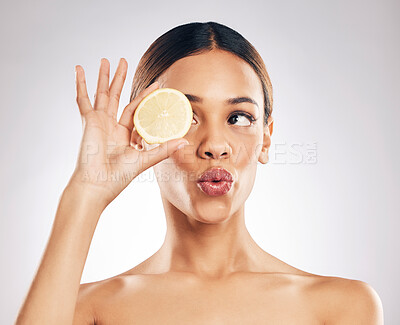 Buy stock photo Woman, kiss face and lemon with beauty, skincare with organic cosmetic product isolated on studio background. Natural cosmetics, female model with pout and citrus fruit for skin glow with dermatology