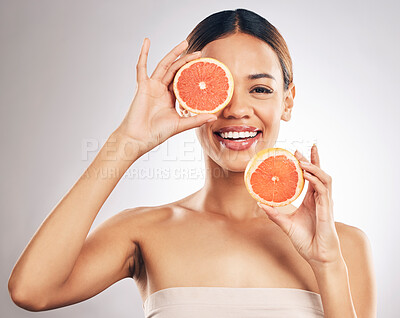 Buy stock photo Portrait, skincare and happy woman with grapefruit in studio fo organic, cosmetic or treatment on grey background. Citrus, face and female model with fruit for eco, vegan or skin detox with vitamin c