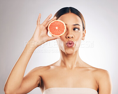 Buy stock photo Grapefruit, skincare and woman in studio for natural cosmetic, treatment and beauty on grey background. Citrus, facial and female model relax with fruit for vegan, detox and vitamin c or glowing skin