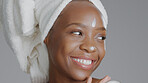 Face, product and beauty with a model black woman in studio on a gray background for skincare treatment. Portrait, towel and lotion with an attractive young female indoor to apply facial moisturizer
