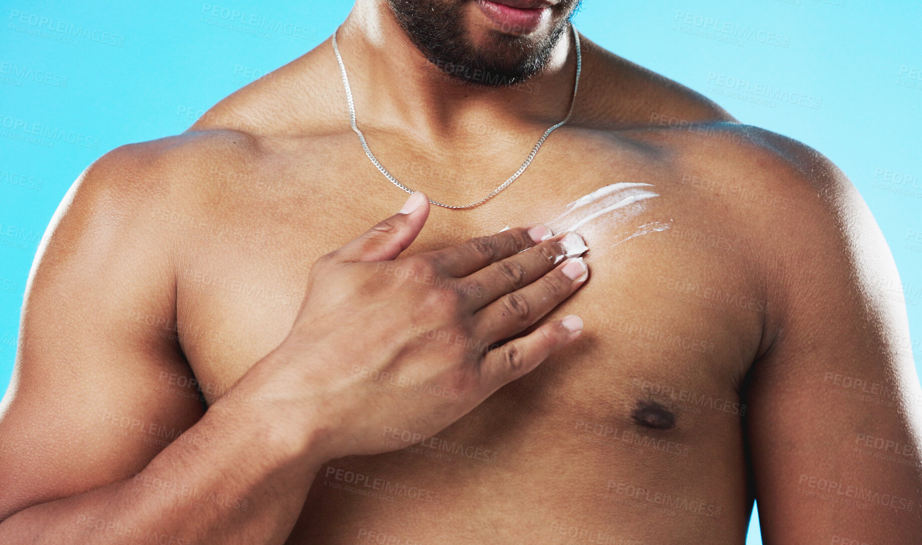 Buy stock photo Skincare, body or man with cream on chest isolated on a blue background in studio for hydration. Hand closeup, sexy or model applying sunscreen, lotion creme or moisturizer for grooming or beauty